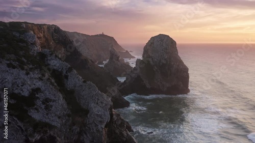 Drone footage of wild place with rare beauty of the sea. Sharp scarps between cliffs and many rocks brought by the ocean as seen from top. Europe, Portugal, Sintra, Ursa Beach. High quality 4k footage photo