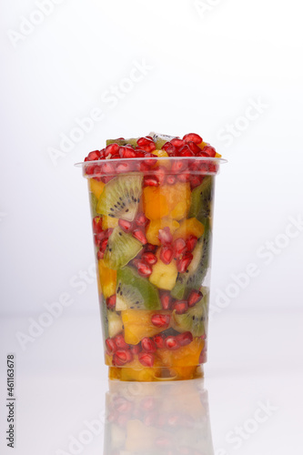 Mixed cut fruits arranged in a transparent tableware   isolated.