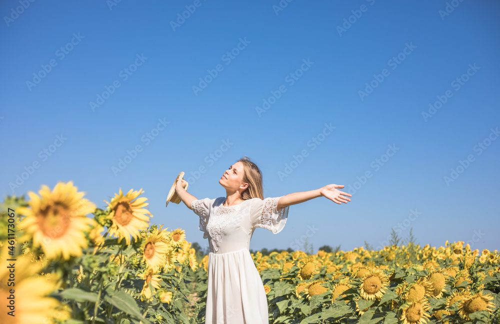 Beauty sunlit woman on yellow sunflower field Freedom and happiness concept. Happy girl outdoors Beauty sunlit woman on yellow sunflower field Freedom and happiness concept. Happy girl outdoors