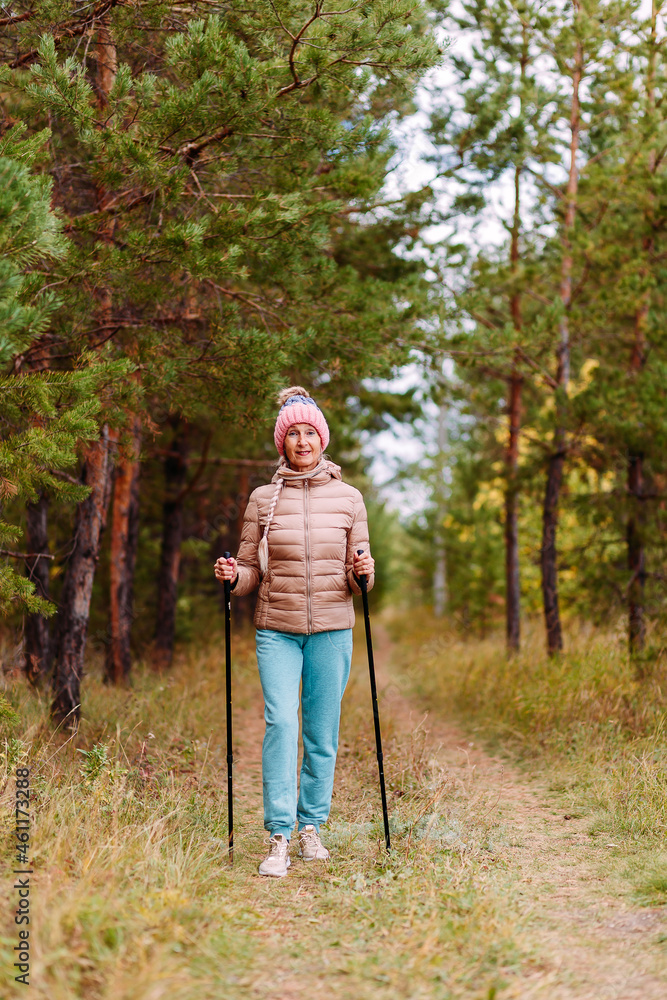 Obraz premium an elderly woman in sportswear with sticks