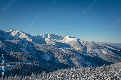 Snowy ridges of Western Tatra Mountains in December, Slovakia. Clear blue sky, cold weather and stunning view from Lúčna (Grześ) Peak. Selective focus on the lines, blurred background. photo