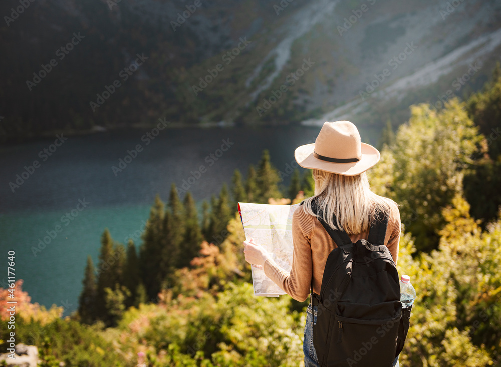 Woman traveler wearing hat and looking at amazing mountains and lake Woman traveler wearing hat and looking at amazing mountains and lake