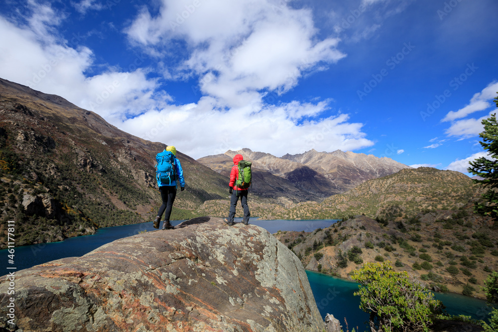 Two women backpackers hiking  in beautiful winter mountains