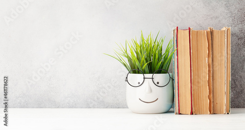 Table with books and plant with glasses