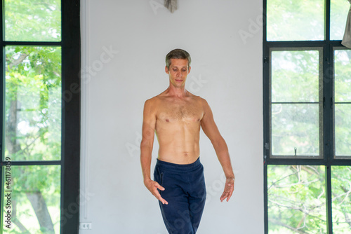  Confidence Caucasian male ballet dancer practicing ballet dance alone in studio room. Handsome man athletic dancing classic ballet showing performance body stretching and strength muscle.