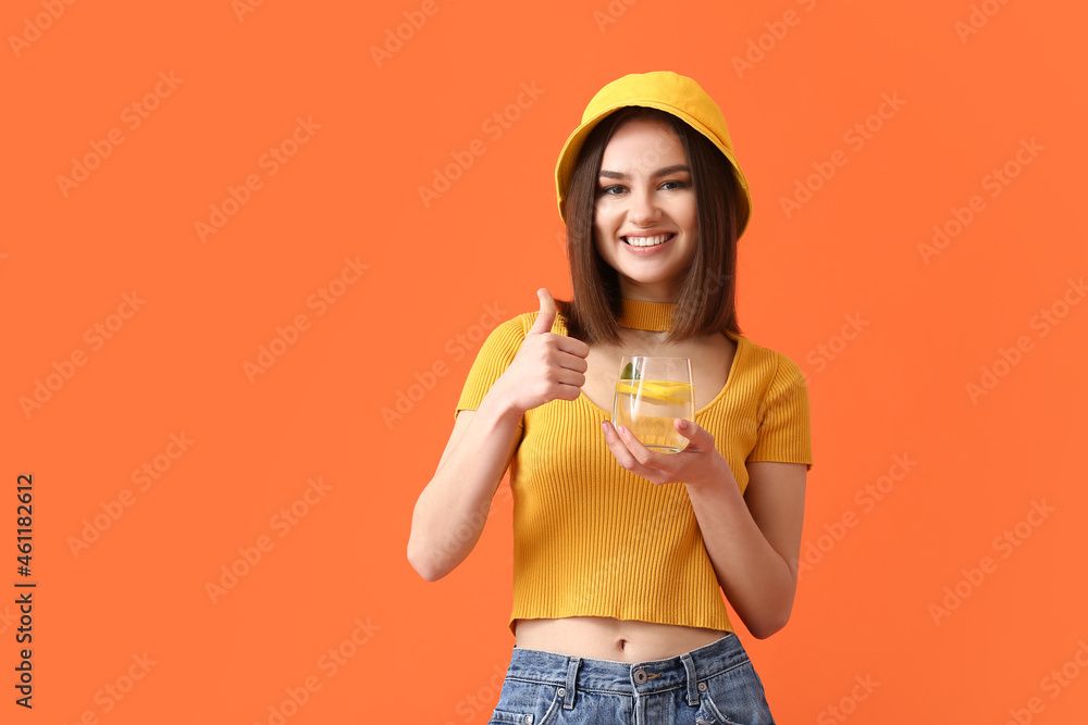 Beautiful young woman with fresh lemonade showing thumb-up on color background Beautiful young woman with fresh lemonade showing thumb-up on color background
