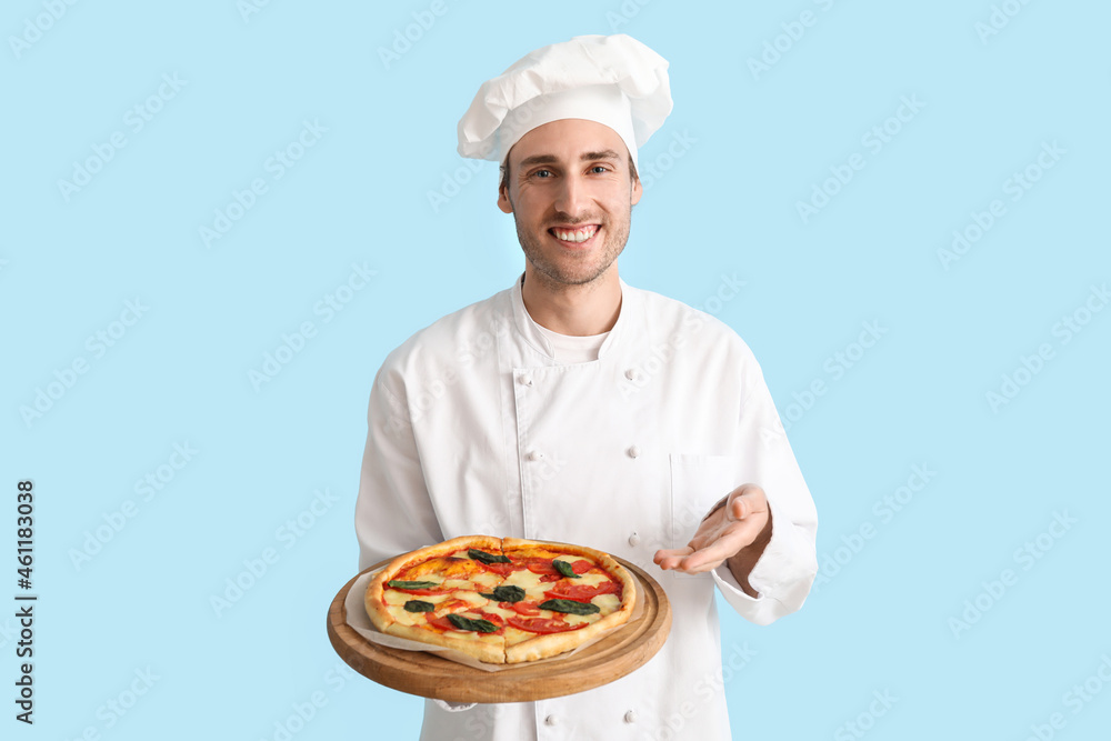 Handsome chef showing tasty pizza on blue background Handsome chef showing tasty pizza on blue background
