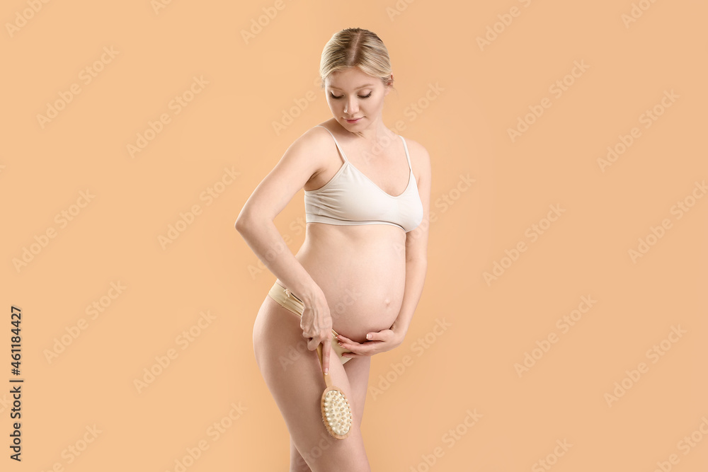 Beautiful pregnant young woman with massage brush on color background Beautiful pregnant young woman with massage brush on color background