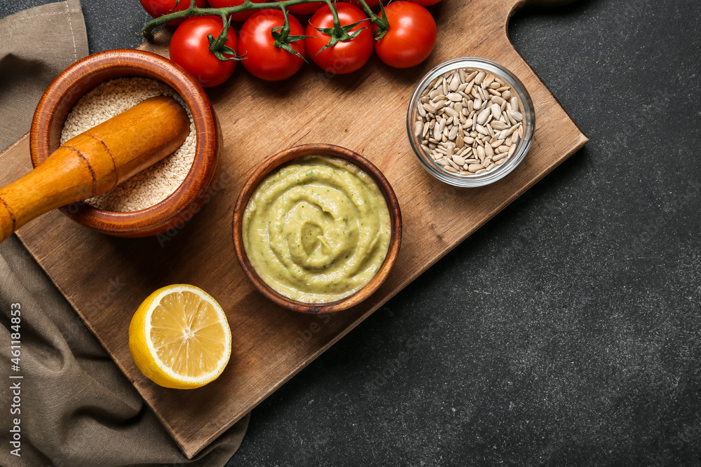 Bowl with tasty baba ghanoush, mortar and products on dark background Bowl with tasty baba ghanoush, mortar and products on dark background
