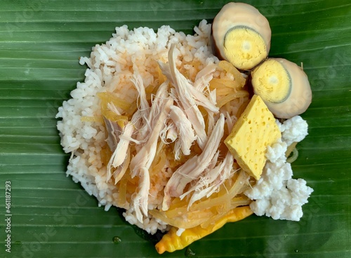 Nasi Liwet Solo, a traditional food from Surakarta, Indonesia, savory steamed rice with pulled chicken curry and chicked egg photo