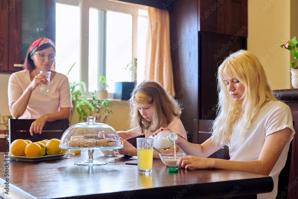 Family, girls, children eating at the table in the kitchen