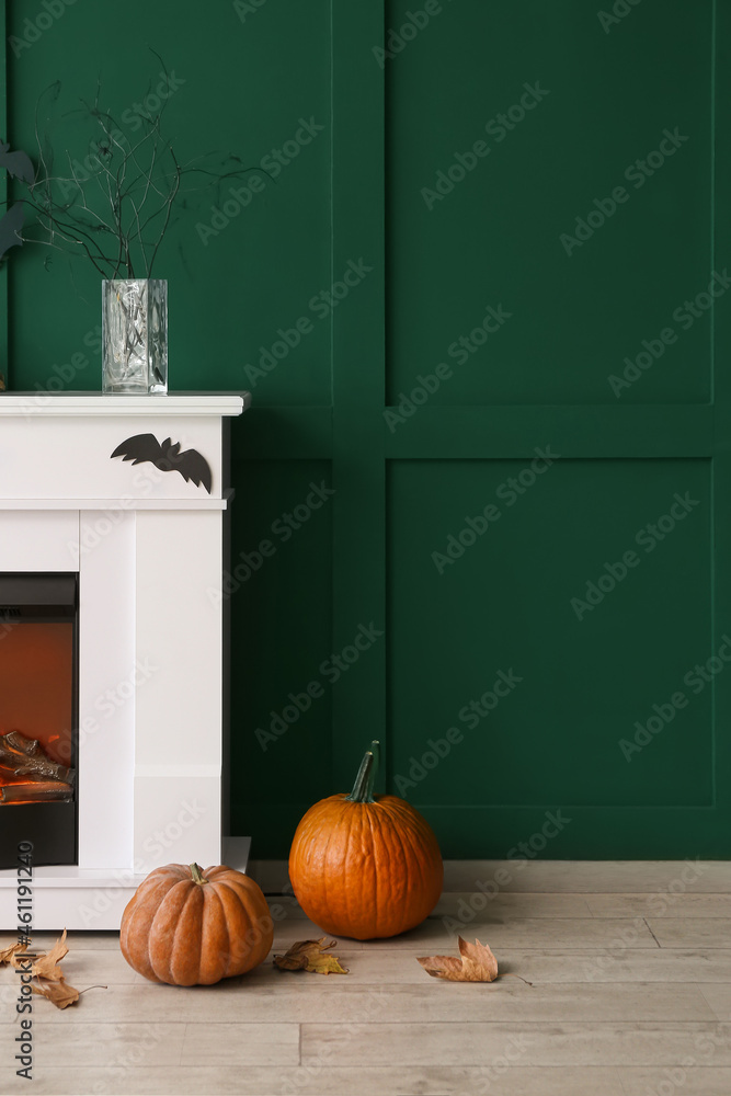 Fototapeta premium Fireplace decorated for Halloween party near color wall in room