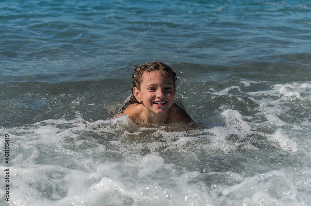 Little happy adorable girl child swims in the sea and plays on the waves during the holidays on the sea coast
Little happy adorable girl child swims in the sea and plays on the waves during the holidays on the sea coast