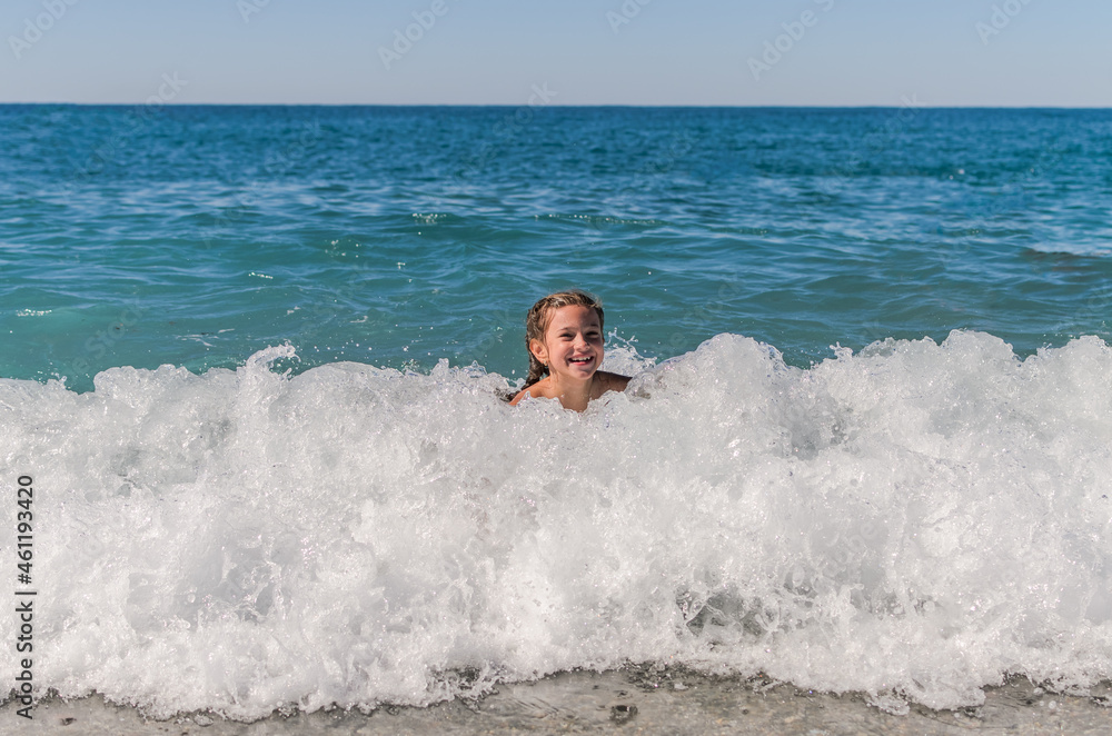 Little happy adorable girl child swims in the sea and plays on the waves during the holidays on the sea coast
Little happy adorable girl child swims in the sea and plays on the waves during the holidays on the sea coast