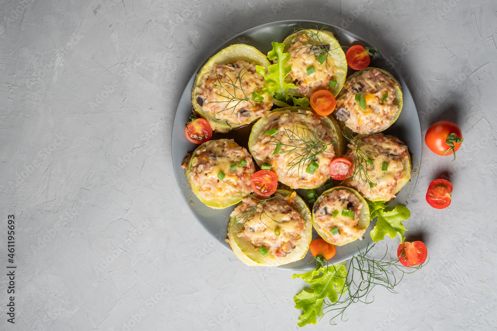 Zucchini stuffed with meat and rice with tomatoes, dill, lettuce on a round plate. Zucchini stuffed with meat and rice with tomatoes, dill, lettuce on a round plate.