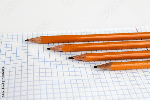Pencils lie on a blank notebook sheet, white background, School topics