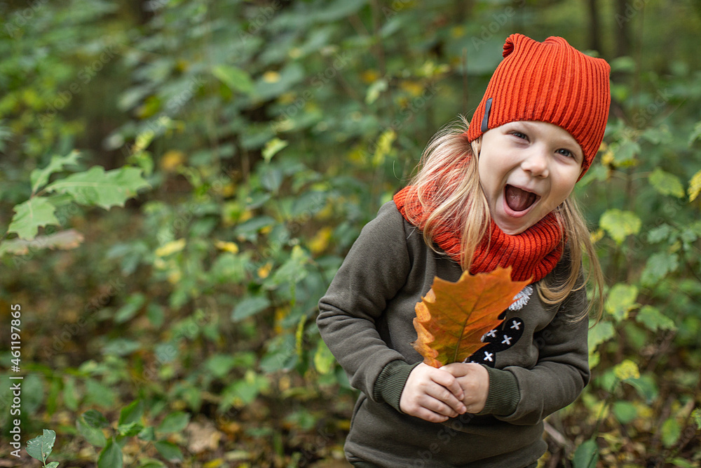 smiling girl with autumn leaves in her hands in an orange hat on the background of nature smiling girl with autumn leaves in her hands in an orange hat on the background of nature