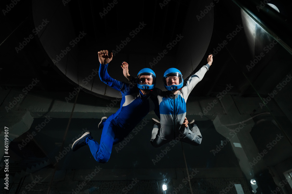 A man and a woman enjoy flying together in a wind tunnel. Free fall simulator A man and a woman enjoy flying together in a wind tunnel. Free fall simulator