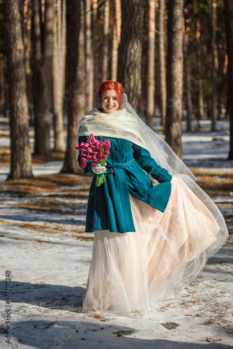 beautiful bride with a bouquet of tulips in the winter forest © Roman