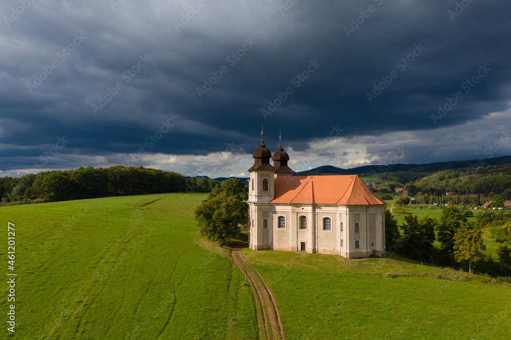 Church of St. Margaret from the 18th century near Šonov. 
Beautiful church chapel in middle of fields in czech countryside broumovsko region with hills of broumov walls on background. Aerial view 
