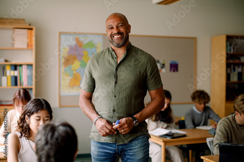 Portrait of male teacher standing in classroom photo