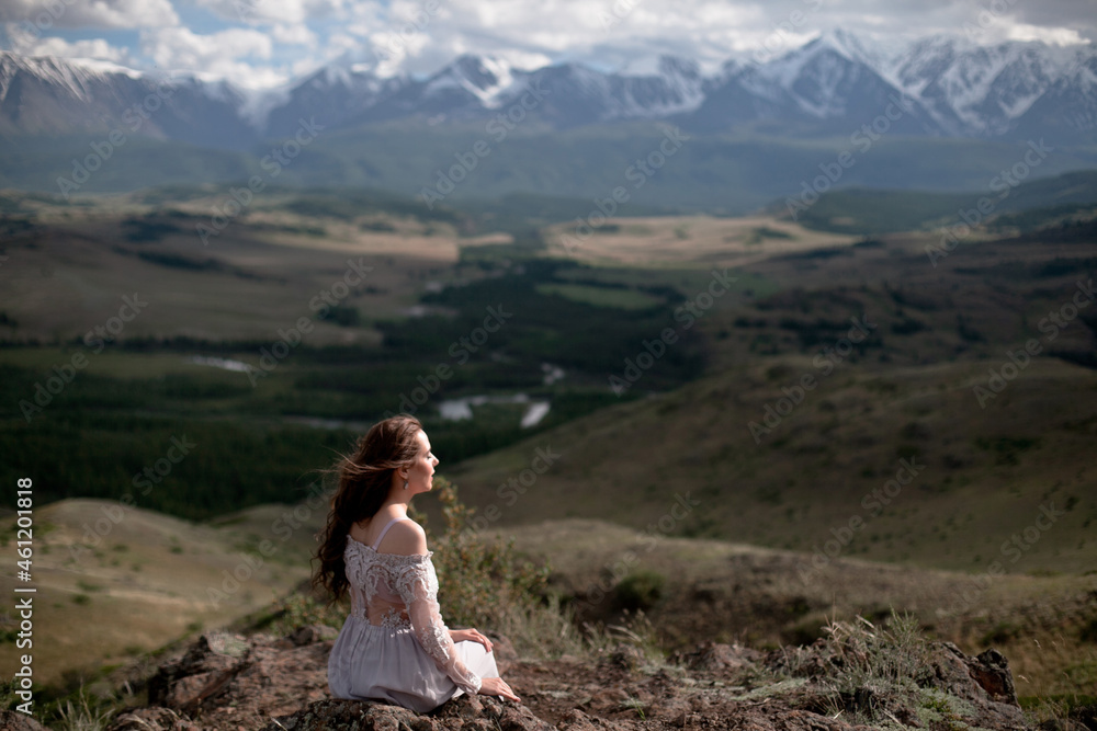 A beautiful girl in a gray dress walks against the backdrop of a mountain range. Wind in your hair. Kurai steppe. Severo-Chuisky Khrbet. Altai mountains. Photoshoot in a fairy-tale style. A beautiful girl in a gray dress walks against the backdrop of a mountain range. Wind in your hair. Kurai steppe. Severo-Chuisky Khrbet. Altai mountains. Photoshoot in a fairy-tale style.