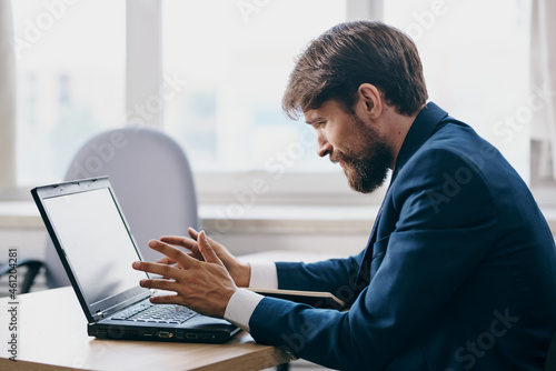 businessmen in the office at the desk in front of a laptop career official