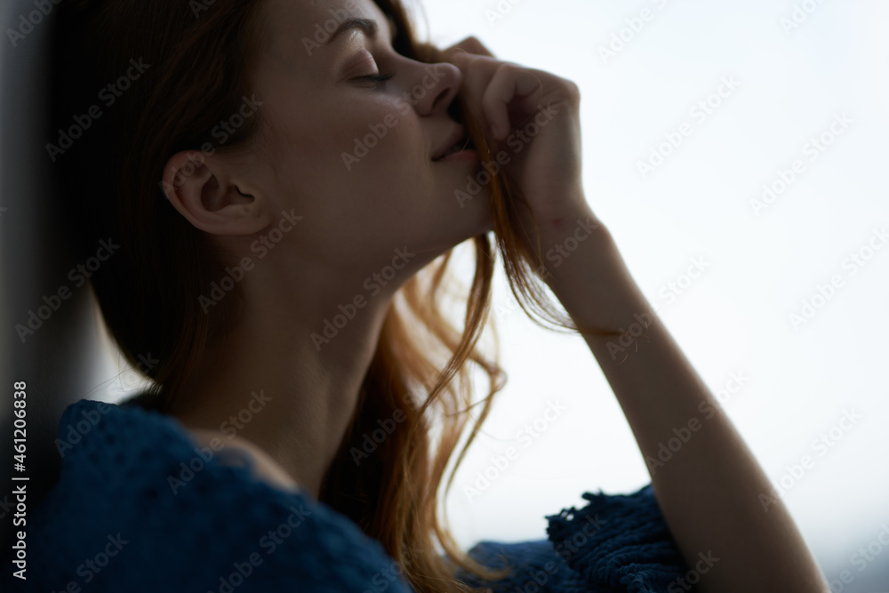 woman sitting on the windowsill with a blue plaid morning woman sitting on the windowsill with a blue plaid morning