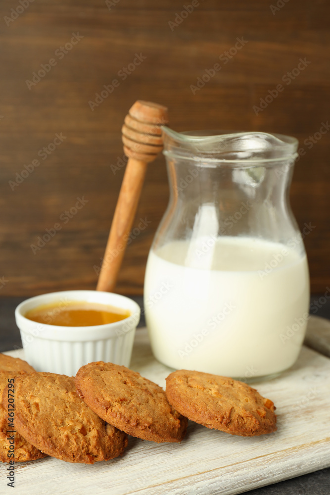 Milk, honey and pumpkin cookies against wooden background Milk, honey and pumpkin cookies against wooden background