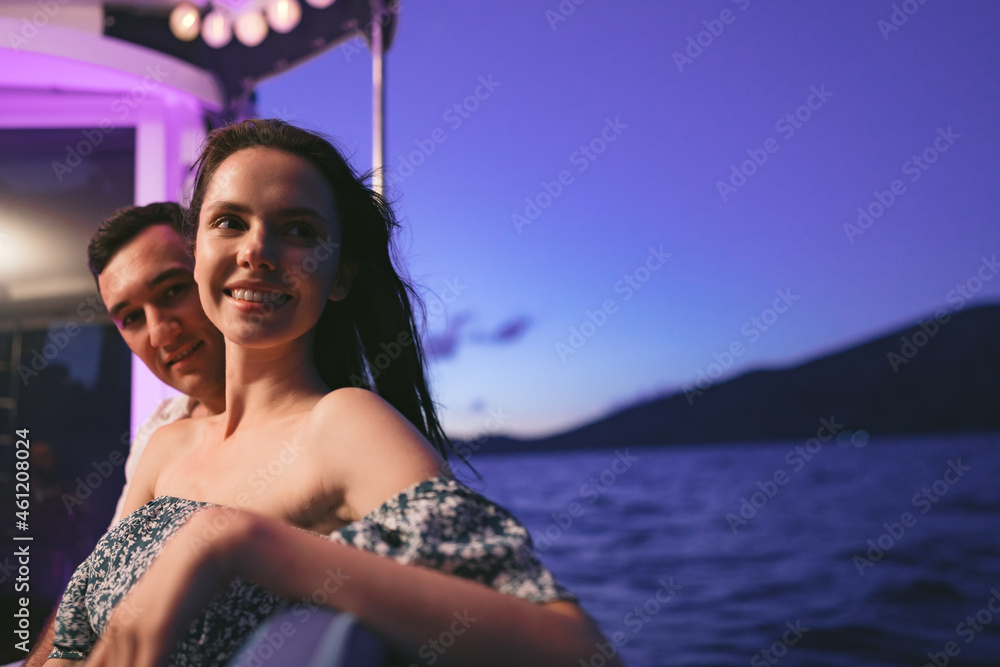 Portrait of happy couple on the yacht in the evening