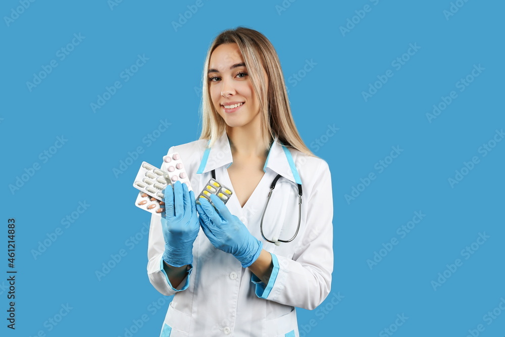 doctor woman holds different pills packages close up on blue background, studio photo shoot. concept of medical treatment. doctor woman holds different pills packages close up on blue background, studio photo shoot. concept of medical treatment.