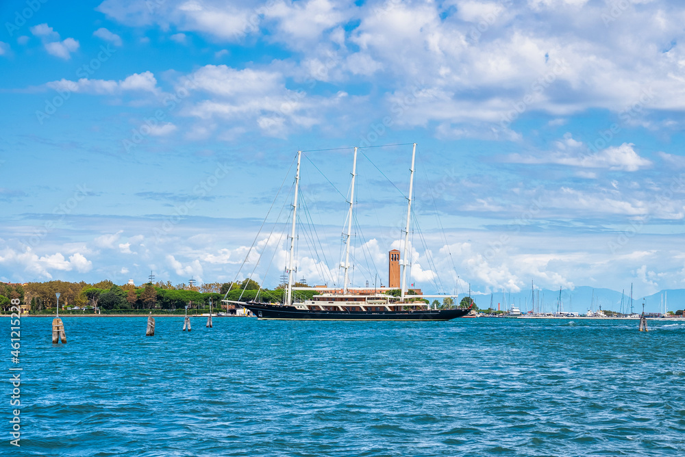Obraz premium Huge sailing yacht entering Venice city in Italy. Luxury yacht sailing down the Adriatic sea in Venice.