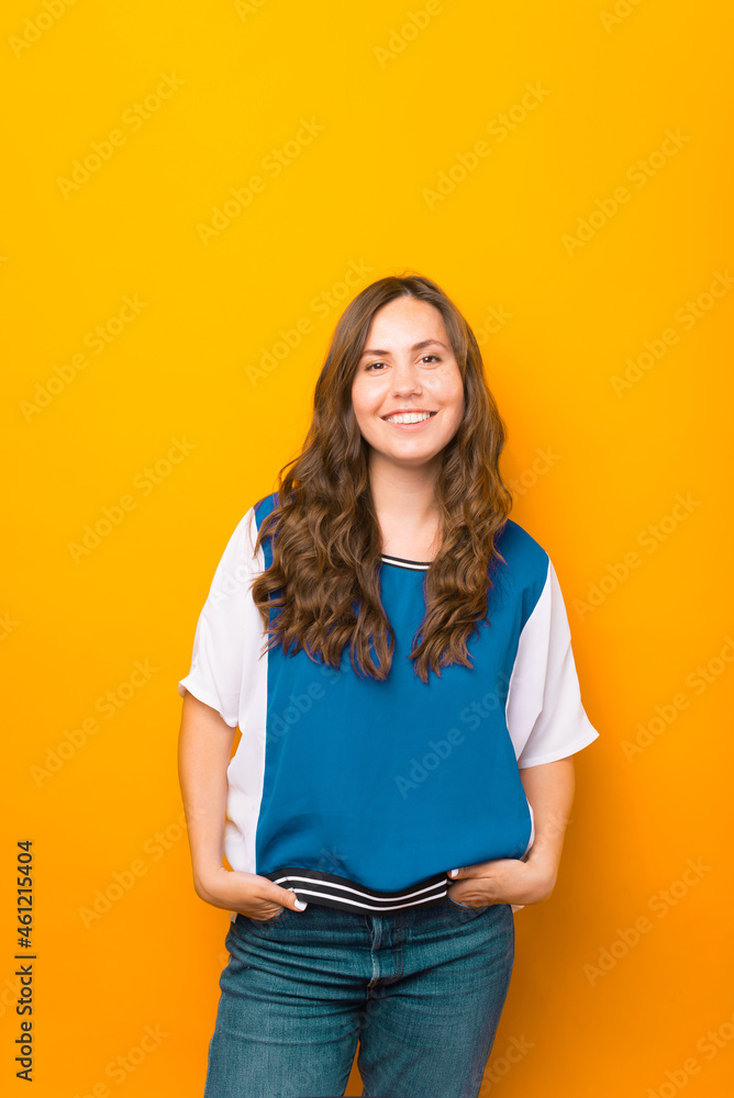 Vertical photo of a young lady standing with her hands in the pockets. Vertical photo of a young lady standing with her hands in the pockets.