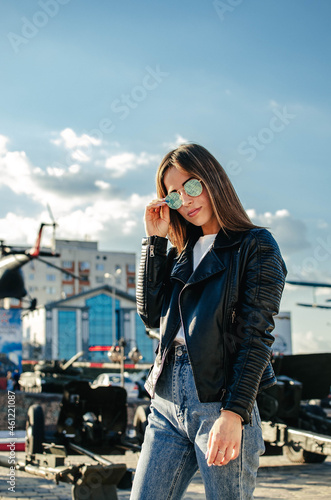 Portrait of a fashionable young woman with sunglasses on the street in bright sunlight