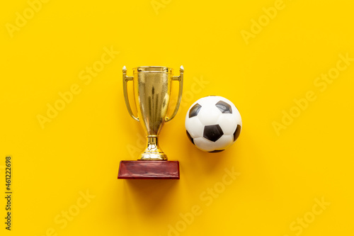 Sport champion award - golden trophy cup with game ball, top view