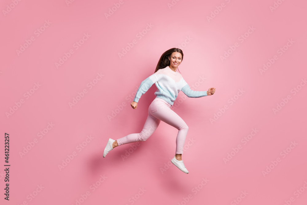 Full body profile side photo of attractive active young woman run jump up isolated on pastel pink color background Full body profile side photo of attractive active young woman run jump up isolated on pastel pink color background