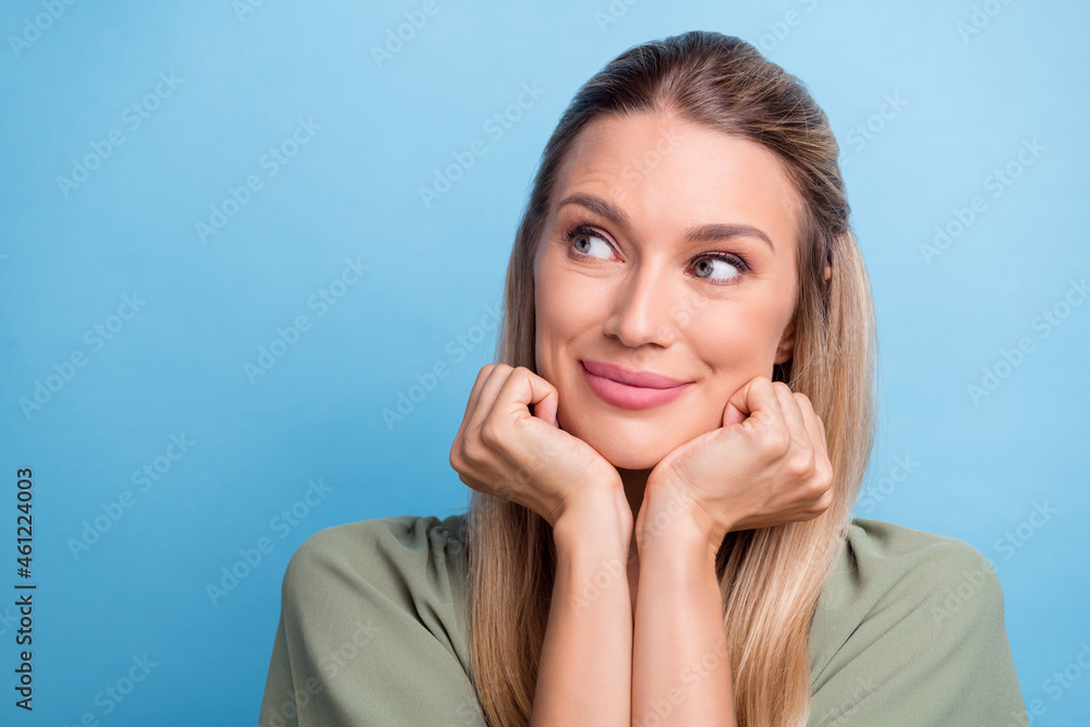 Photo of cute dreamy young woman dressed green clothes arms cheeks chin looking empty space smiling isolated blue color background Photo of cute dreamy young woman dressed green clothes arms cheeks chin looking empty space smiling isolated blue color background