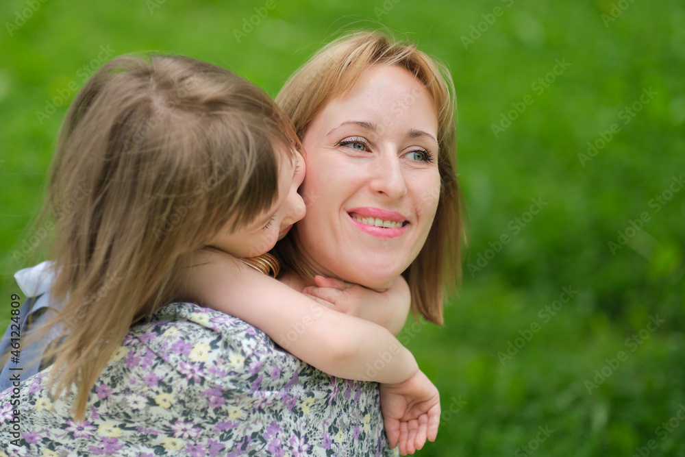 Side view close up head shot happy cute daughter hugging embracing cuddling mother. Concept of happy family. Portrait happy smiling child hugging mother in summer day Side view close up head shot happy cute daughter hugging embracing cuddling mother. Concept of happy family. Portrait happy smiling child hugging mother in summer day