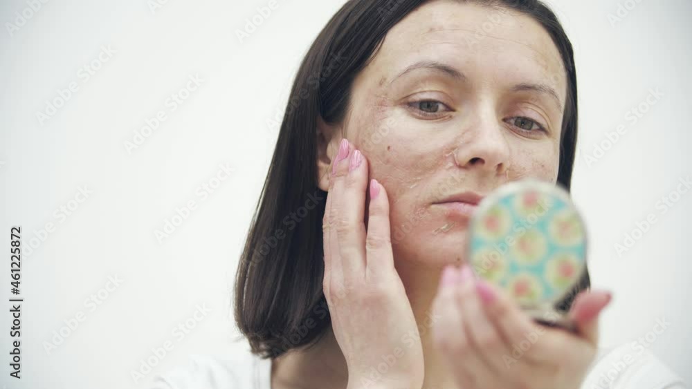 4k video of close up female face with dry skin looking in the mirror. 4k video of close up female face with dry skin looking in the mirror.
