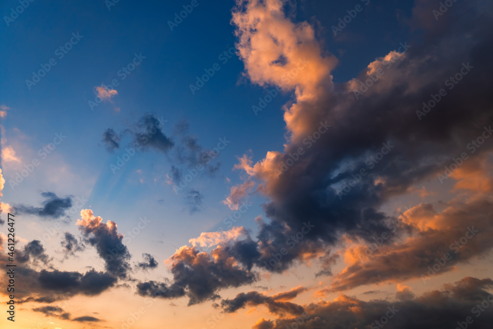 beautiful sunset for background - evening sky with clouds of bright orange and red is illuminated by the sun