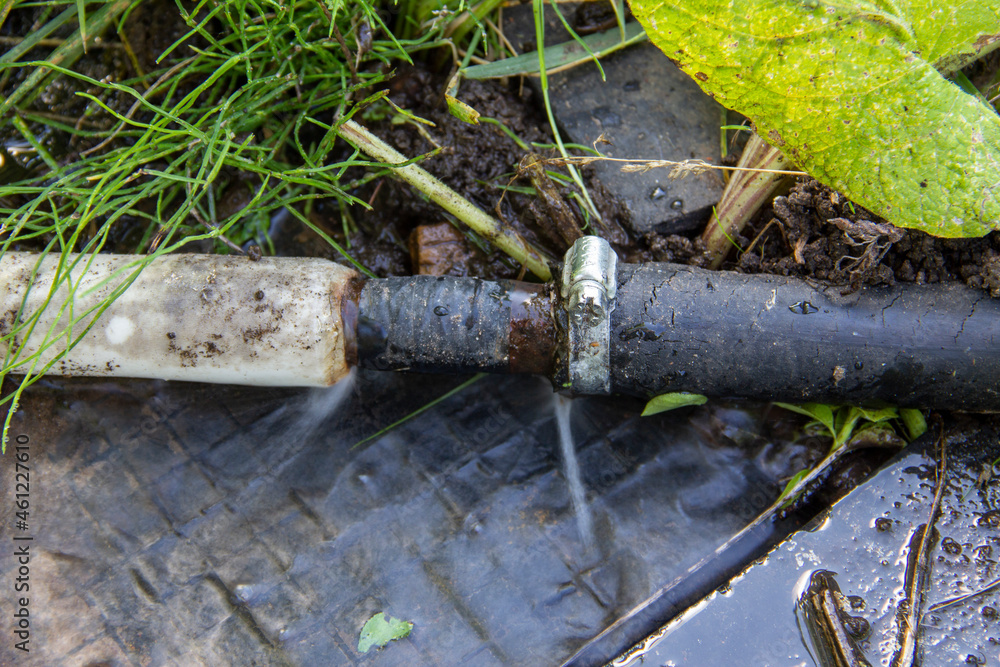 a hole in a hose with water and a pipe bursting, a hose with a flowing