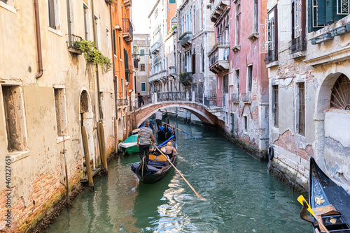 Traditional gondolas on the narrow canal in Venice, Italy. Exploring beautiful Venice on water on a sunny day.