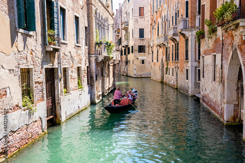 Traditional gondolas on the narrow canal in Venice, Italy. Exploring beautiful Venice on water on a sunny day. © Aerial Film Studio