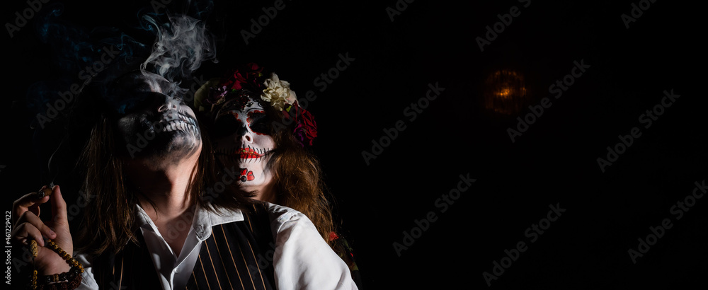 Woman in santa muerte costume and man in skeleton bodypainting for halloween. - obrazy, fototapety, plakaty 