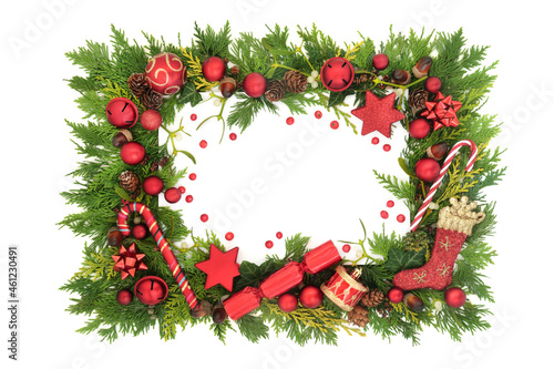 Abstract Christmas background frame, traditional red bauble tree decorations, winter greenery with loose red holly berries. Festive composition for the Xmas holiday season on white with copy space. 