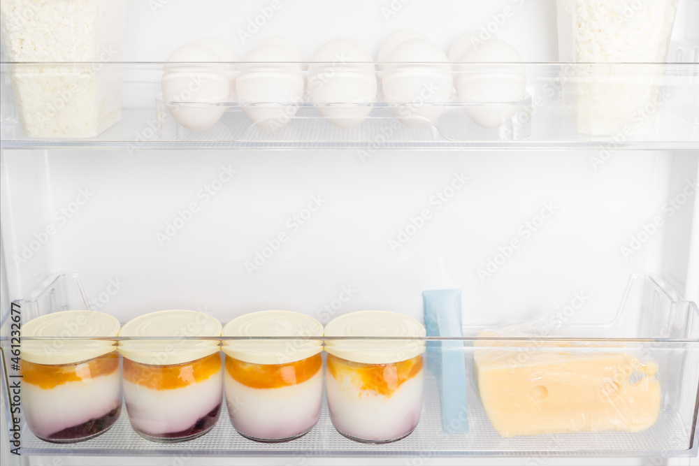 eggs and yoghurts are on the shelves in the refrigerator door, close-up view eggs and yoghurts are on the shelves in the refrigerator door, close-up view