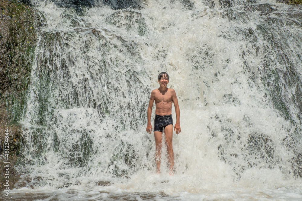 The joy of a boy bathing in a waterfall. The joy of a boy bathing in a waterfall.