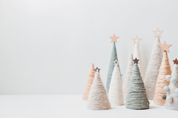 Christmas craft background with handmade yarn cone xmas trees in natural colors.  DIY organic sustainable christmas decoration