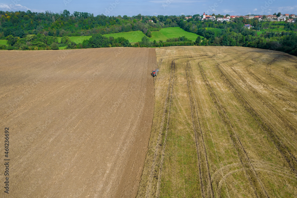 Plowing the land with a tractor, aerial view.