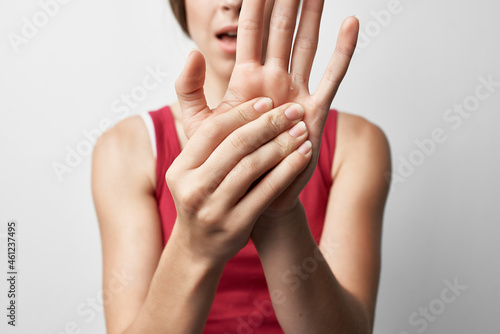 woman in red t-shirt joint pain injury hand treatment